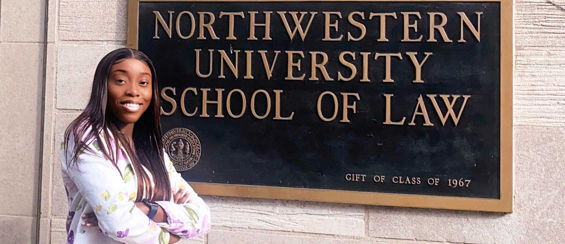 Jehovahnie Saint-Rose standing by Northwestern University School of Law sign