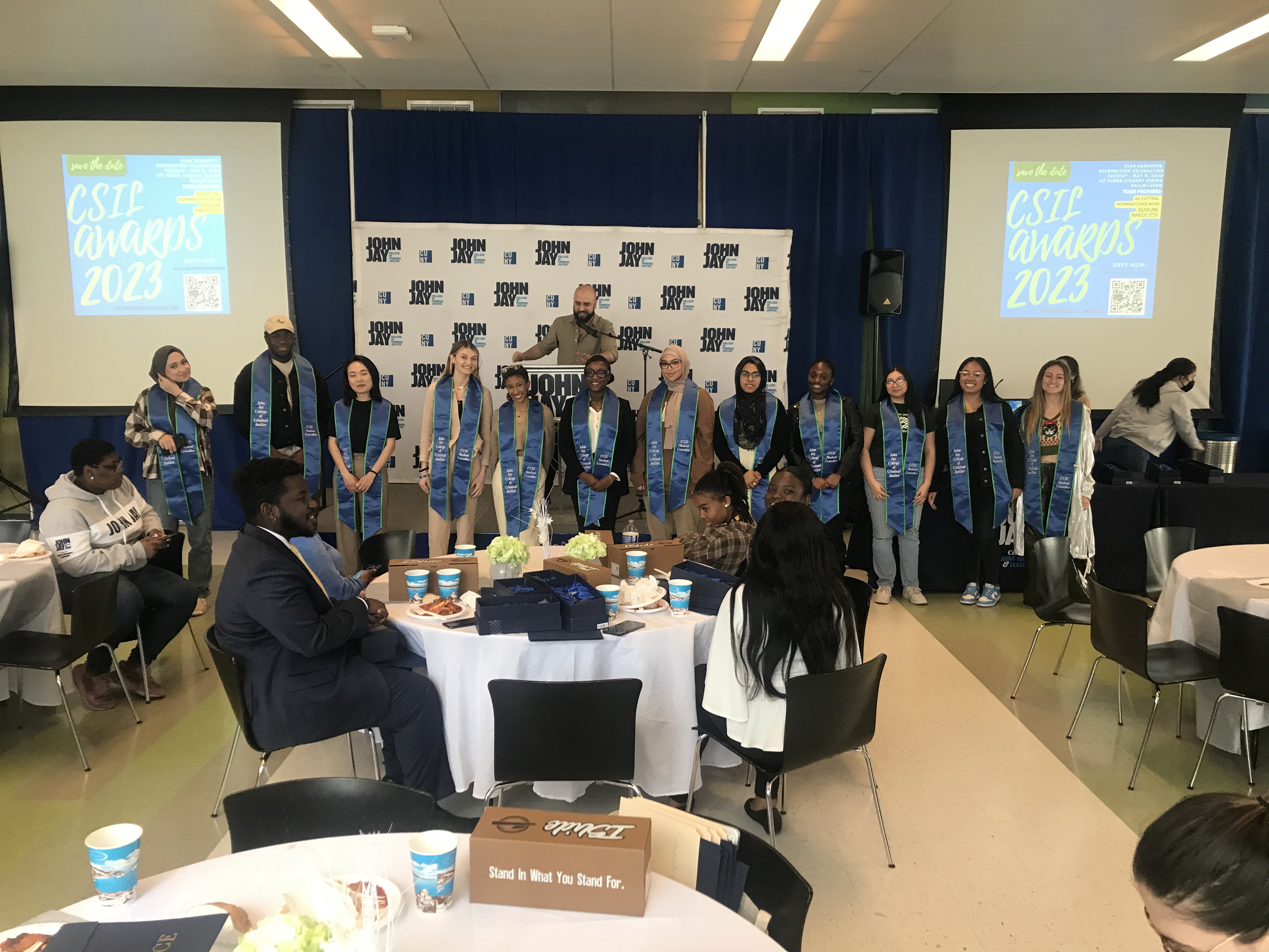 Graduating student executives standing in front of a stage as they get recognized for their hard work within the JJC community.