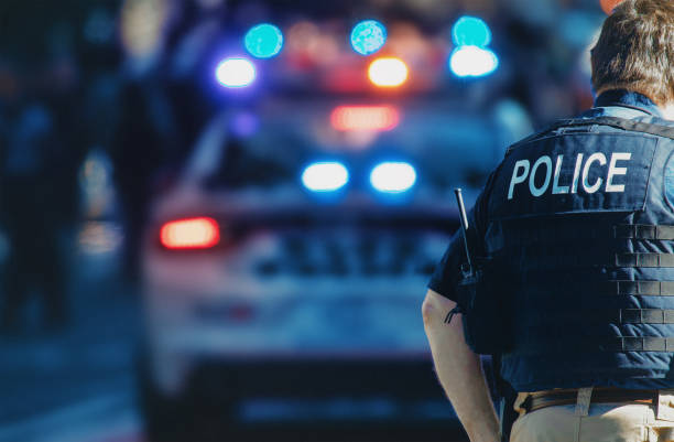 Police Officer with Patrol Car in Background