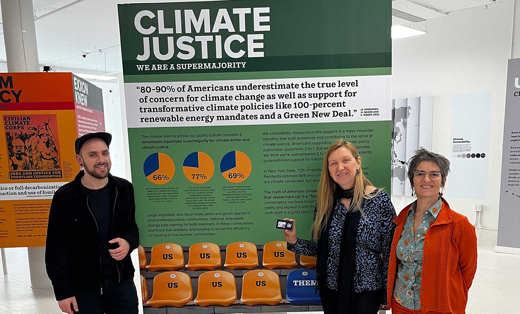 John Jay Faculty members in front of a Climate Justice poster