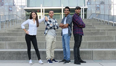 Four students standing on the steps of the Jay Walk