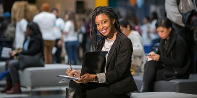 Student with notepad in the Atrium