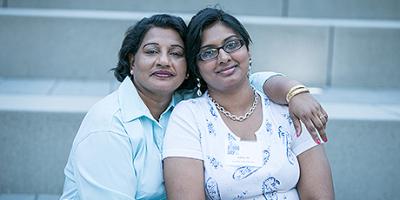 Older woman wrapping her arm around a young woman