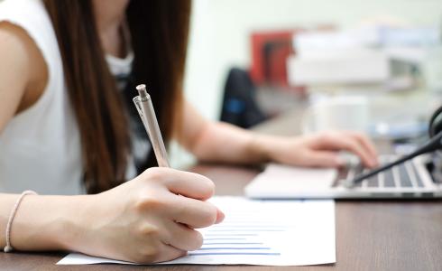 student taking notes with laptop