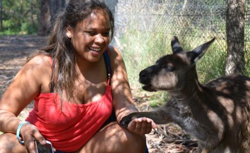 JJC student in Australia crouching next to a wallaby