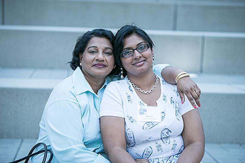 Older woman wrapping her arm around a young woman