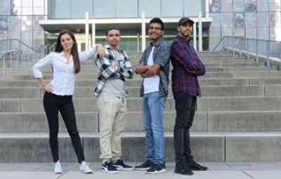 Four students standing on the steps of the Jay Walk